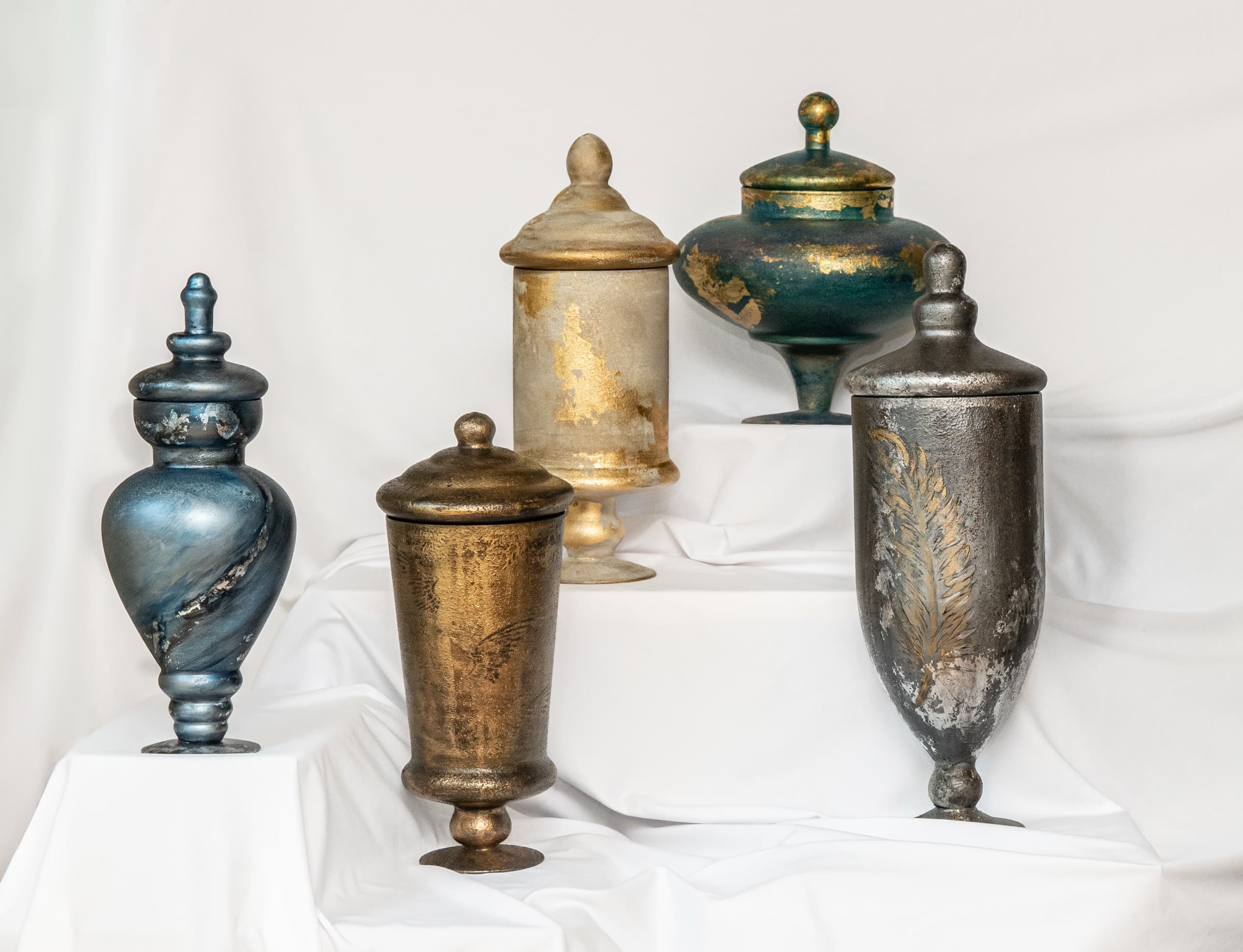 Heritage memorial vessels arranged together on ivory draping