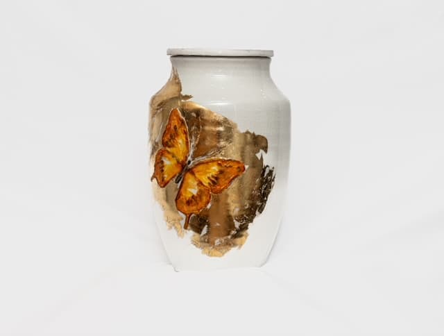 Ivory memorial vessel with an amber monarch butterfly and gold surface