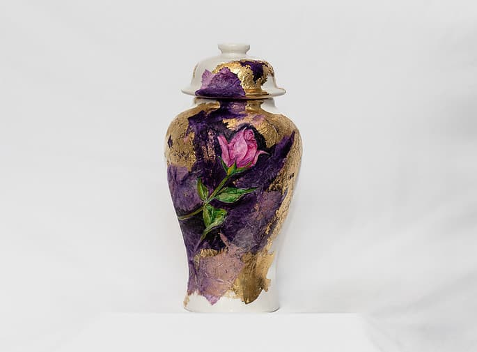 Tall cream memorial vessel with a sculpted rose and purple-gold surface